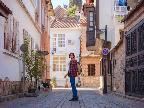 travel to Turkey, old town Antalya Kaleci Famous tourist destination . Happy asian female tourist traveller with backpack walks in old city.