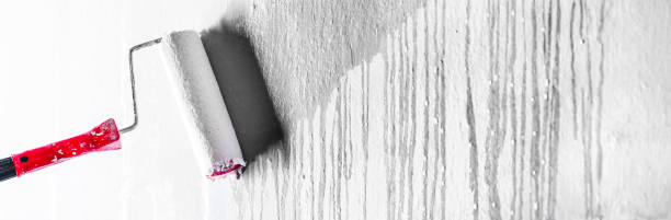 istock Roller Brush Painting wals, Worker painting on clean surface wall by white roller. 1404833500