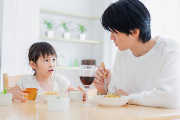 istock Little girl eating with daddy 1404834753