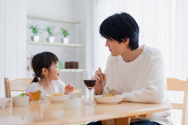 istock Little girl eating with daddy 1404834754