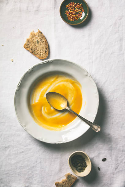 istock Empty plate of pumpkin soup on white tablecloth 1404834821