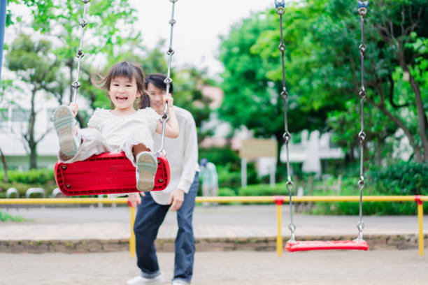 istock Little girl playing in the park with her daddy 1404836434