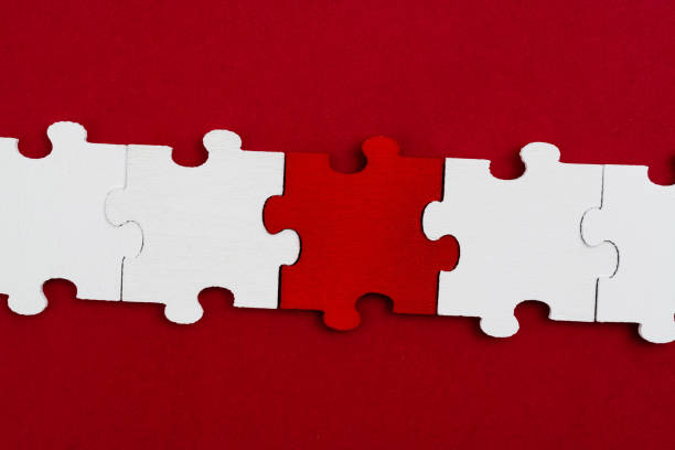 A row of jigsaw pieces on red background.