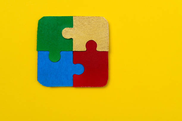 istock Four jigsaw pieces on yellow background 1404838778