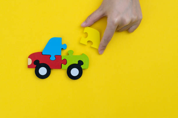 Human hand playing a jigsaw puzzle car.