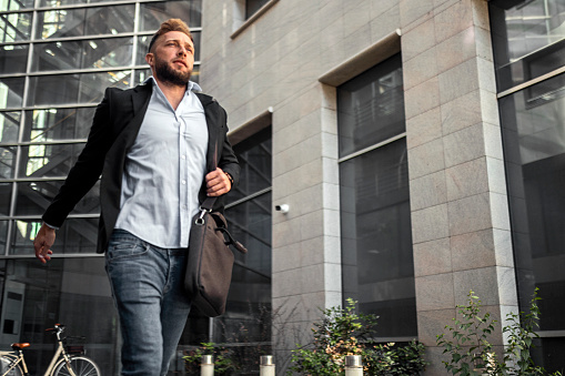 Young man getting late on work running