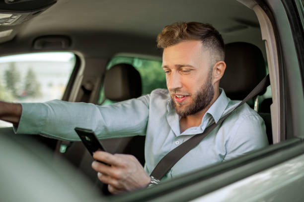 istock Serious businessman driving a car text messaging 1404839067