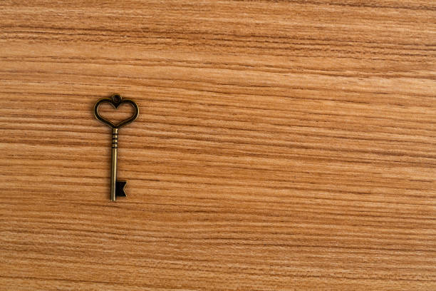 istock Key with a heart shape on wooden table 1404839647