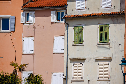 Residential houses in the town of Rovinj, pastel colored facade, wooden shutters on window frames