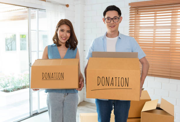 istock Recycling, Donation for poor, smiling asian family pack, holding donate box full with second hand clothes, charity helping and needy people. Reuse recycle. 1404845726