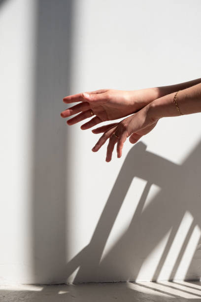 istock Women's hands, shot in harsh sunlight with fashionable shadows. 1404845928