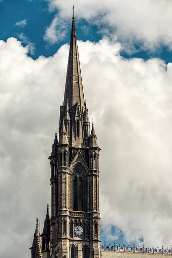 Cobh, Ireland - July 29, 2019: Cathedral Church of St. Colman, tower detail. The Cathedral Church of St. Colman, usually known as Cobh Cathedral, is a single-spire cathedral in Cobh, Ireland. It is a Roman Catholic cathedral and was completed in 1919. It is dedicated to Colmán of Cloyne, patron saint of the Diocese of Cloyne. It serves as the cathedral church of the Diocese. It is one of the tallest buildings in Ireland, standing at 91.4 metres (300 ft).