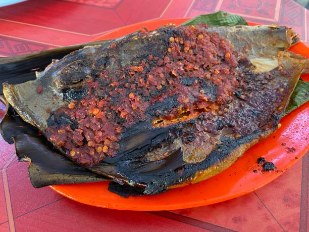 istock Stingray Fish with Sambal Chili Paste Sauce with Chopped Onions Cilantro and Fermented Shrimp Dipping Sauce on banana leaf. 1404847302