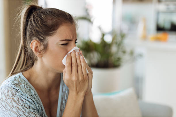 istock Young woman  blowing nose with a napkin 1404847390