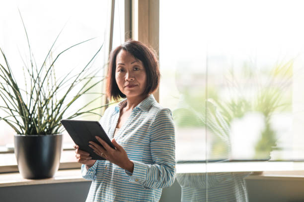 istock Successful Asian Businesswoman Reading Emails With A Digital Tablet 1404848326