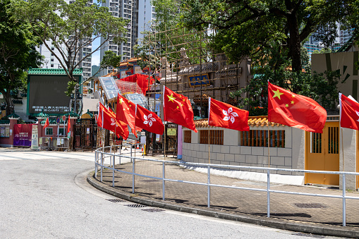 Hong Kong - June 24, 2022 : The flags of China and Hong Kong at Wong Tai Sin Temple to celebrate the 25th anniversary of Hong Kong's handover from Britain to China.