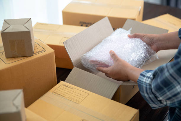 Closeup view of female packing package shipping box stock photo