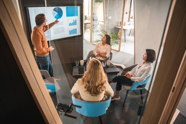 istock Successful Young Male Entrepreneur Explaining Statistics To A Multiracial Board 1404848563
