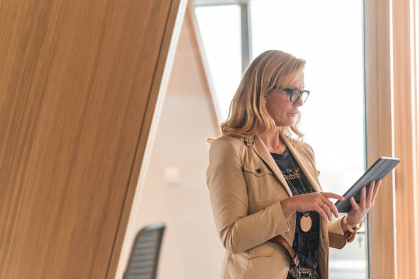 istock Mature Caucasian Marketing Manager Reading Emails On A Digital Tablet 1404848720