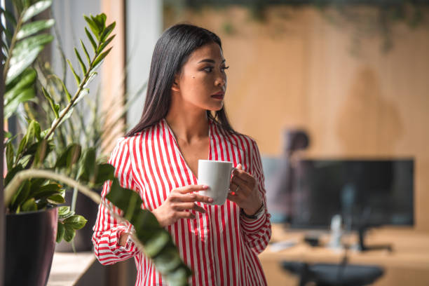 istock Young Chinese Female Office Employee Drinking Coffee 1404848760