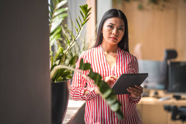 istock Serious Asian Female Social Media Manager Using A Digital Tablet 1404848762