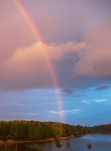 Landscape with big rainbow in the sky at sunset