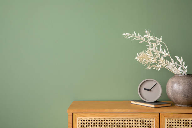 istock Stylish bedroom interior design with mock up poster frames, bed, side table, rattan commode, vanity table and creative home accessories. Sage green wall. Template. Copy space. 1404851700