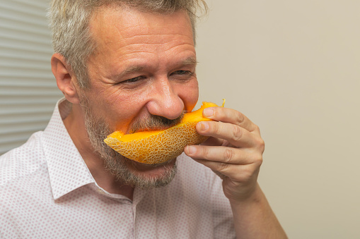 Man eating fresh, ripe slice of melon