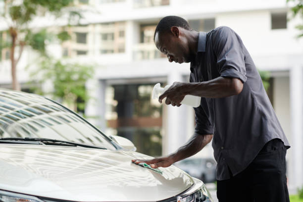 istock Man Removing Bug Stains Off Hood 1404854204