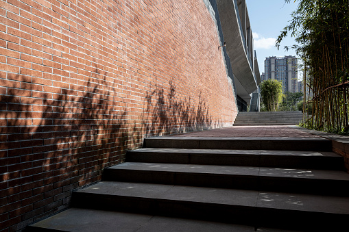 Side view of stair beside brick wall under sunlight