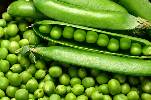 Fresh green peas on an old wooden background