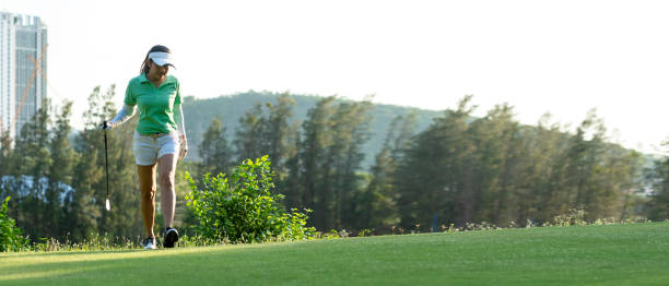 campo sportivo da golf golf ball fairway. persone stile di vita donna rilassarsi dopo swing pallina da golf sul green.  gioco di giocatrice femminile asiatica girato in estate. sano e sport all'aperto, spazio copia per banner - golf swing golf golf club chipping foto e immagini stock