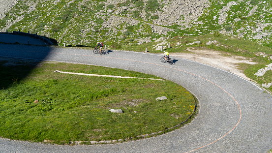 San Gottardo, Switzerland. Cyclists along the bends of the pave road leading to the mountain pass. Grand tour. Historical route