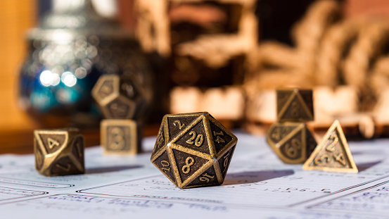 Close-up image of a metallic 20-sided die within the background polyhedral dice