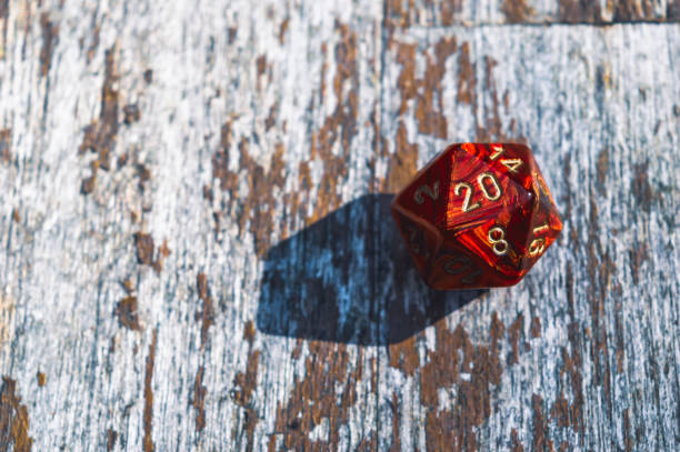 istock Red d20 on a weathered wooden table 1404859460