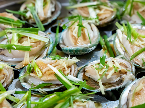 Home cooked baby abalones. These bivalves are freshly steamed and topped with sliced ginger and scallion as garnish. Sprinkle of light soy sauce used for that extra clean flavor. A catering concept.