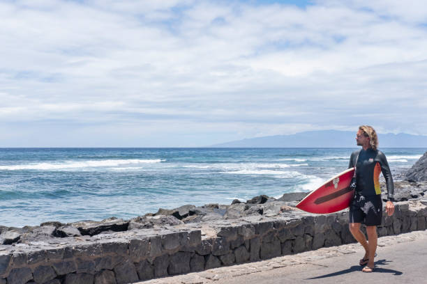 Young woman is getting ready to surf on Canggu beach.Bali Island - Indonesia.