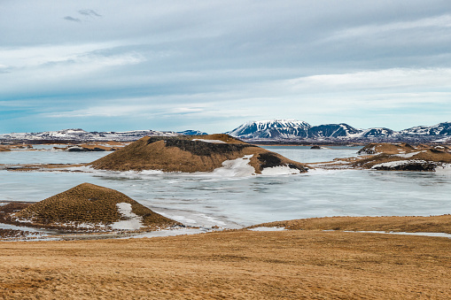 wide angle photography of green grassland with a big puddle in front of jökulsarlon bay and arctic glaciers in the background nearby höfn, iceland