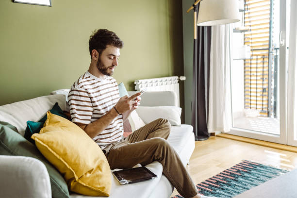 istock Young man is relaxing at home and using mobile phone 1404866539