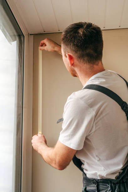 istock Young man applying mounting tape before sealing a window 1404866673