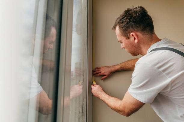 istock Young man applying mounting tape before sealing a window 1404866686