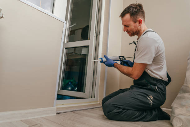 istock Young man wearing overalls sealing a door 1404866885