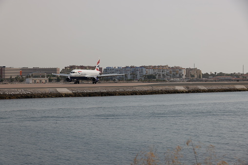 Gibraltar - 16th June, 2022: British Airways aircraft taxis on the Gibraltar airstrip that protrudes into the sea. Gibraltar is a British Overseas Territory