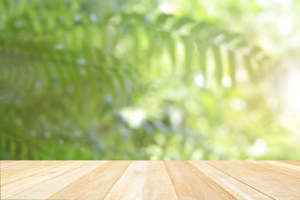 istock Empty top wooden table on defocused abstract bokeh blurred green nature for background 1404869737
