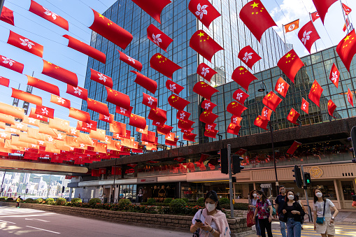 Hong Kong - June 23, 2022 : The flags of Hong Kong and China hang at Tsim Sha Tsui to celebrate the 25th anniversary of Hong Kong's handover from Britain to China.