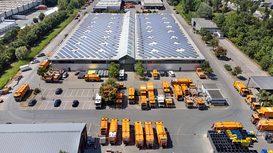 Large industrial building, solar panels and trucks - aerial view