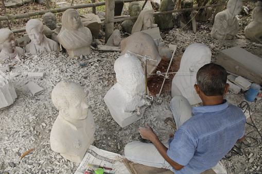 Artist Carving A Half bust Male Model Stone Sculpture.