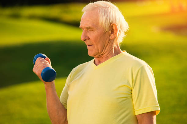 istock Older man holding a dumbbell. 1404872560