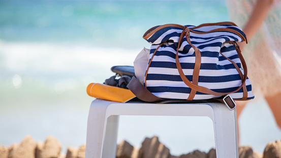 Chair with beach accessories on it - bag and protective cream against the sea, close-up