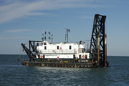 Working dredge and barge in waters of Charleston, South Carolina.